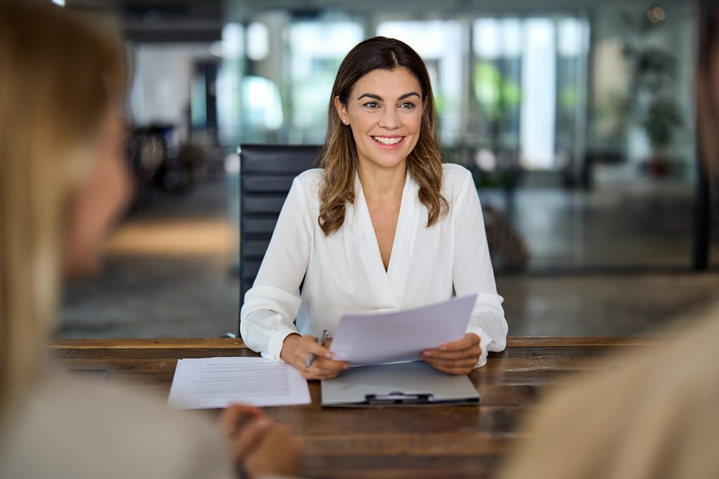 Happy mature business woman banking manager consulting client at office meeting.