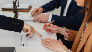 Three people sitting at a table reviewing a divorce decree.