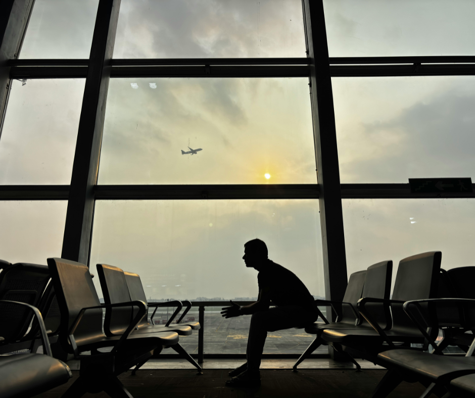 Silhouette of a traveller waiting at an airport as a plane flies overhead, illustrating international travel affected by the Statement of Changes to the UK Immigration Rules.